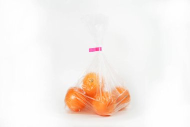plastic bag with fresh fruits on white background