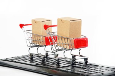 Bilgisayar klavyesinde kutuları olan alışveriş arabaları beyaz arka plan 