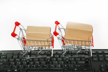 Bilgisayar klavyesinde kutuları olan alışveriş arabaları beyaz arka plan 