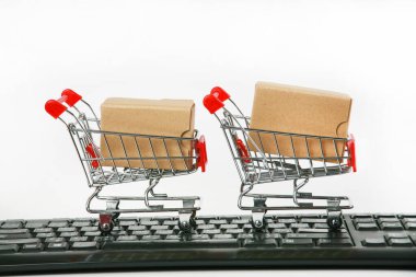 Bilgisayar klavyesinde kutuları olan alışveriş arabaları beyaz arka plan 