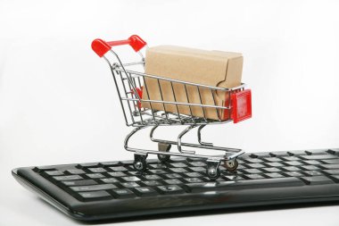 Bilgisayar klavyesinde kutuları olan alışveriş arabaları beyaz arka plan 