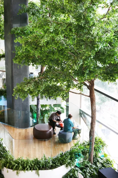 people and green plants in modern building in the city