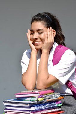 Kitaplar ile üniforma Kolombiyalı öğrenci genç liseli kız gülümseyerek