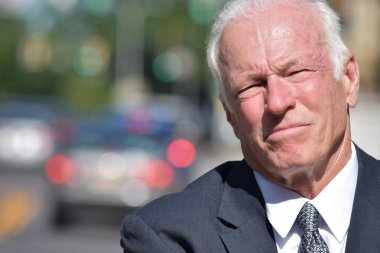 Takım elbise ve kravat şehir merkezinde giyen heyecansız yetişkin üst düzey iş adamı