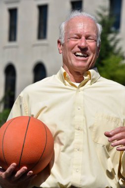 Athlete Senior Male Basketball Coach Smiling With Basketball clipart