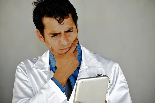 Confused Adult Male Doctor With Tablet