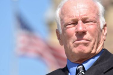 Takım elbise ve kravat giyen heyecansız yetişkin üst düzey politikacı