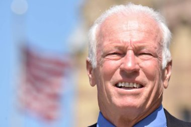 Gülümseyen yetişkin kıdemli erkek siyasetçi takım elbise