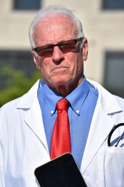 Ciddi erkek Doktor hastanede önlük giyiyor