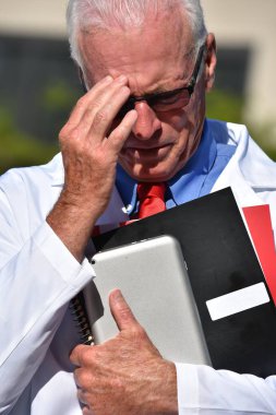 Mutsuz yakışıklı kıdemli erkek önlük giyen hastanede doktor