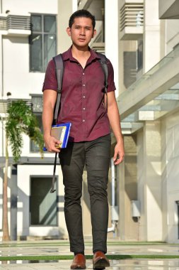 Uzun boylu yakışıklı farklı erkek öğrenci kampüste yürüyüş kitapları ile