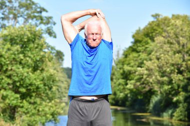 Nehir kıyısında uzanan atletik erkek kıdemli