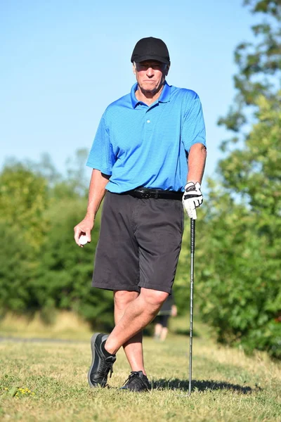 Older Male Golfer Resting With Golf Club Playing Golf