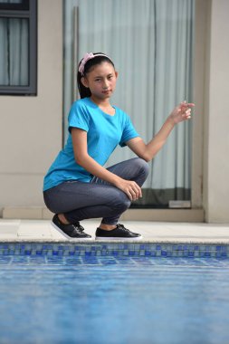 Havuz kenarında oturan güzel genç azınlık erkek