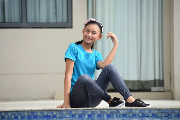 愉快的亚洲女孩坐在游泳池边 — 图库照片