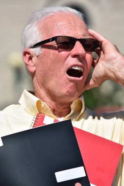 Vurgulanmış Yetişkin Erkek Öğretmen Not Defteri ile güneş gözlüğü takıyor