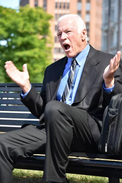 Angry Business Man Sitting On Bench