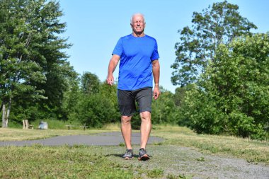 Eski erkek kıdemli egzersiz spor ayakkabı giyen gülümseyen