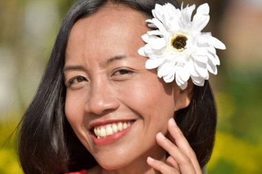 Genç kadın bir çiçek ile gülümseyen