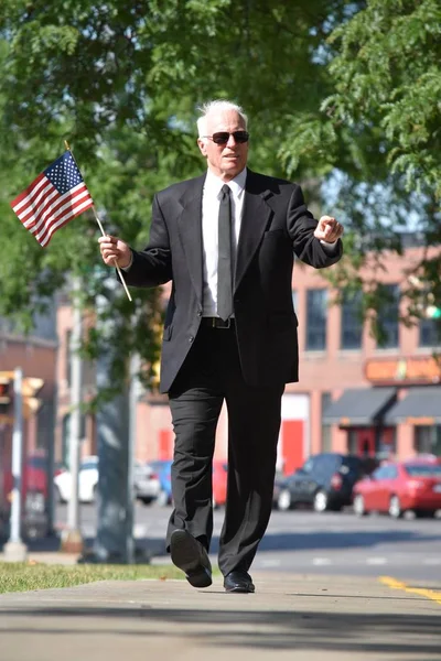 歩道の上を歩くアメリカ国旗を持つ大人の男性政治家肖像画 — ストック写真