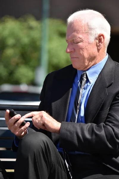 Hombre de negocios adulto mayor haciendo una llamada telefónica usando traje y corbata sentado — Foto de Stock