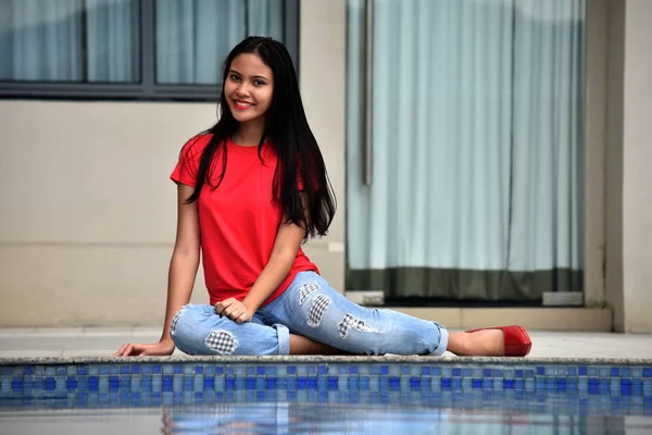 Glücklich schöne philippinische Person sitzt am Pool — Stockfoto