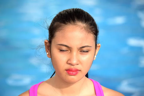 Adolescente chica con los ojos cerrados sentado en la piscina — Foto de Stock