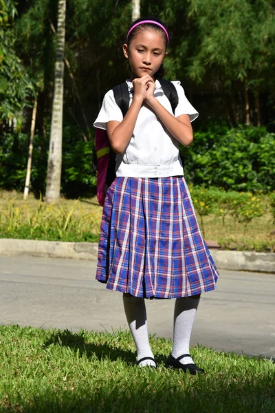Female Student In Prayer Wearing School Uniform