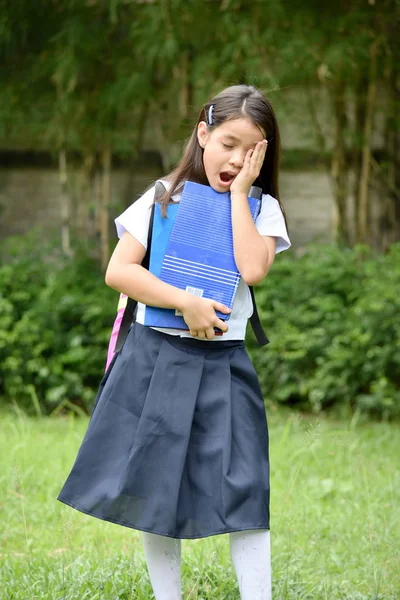 Tired Female Student Wearing Uniform With Notebooks