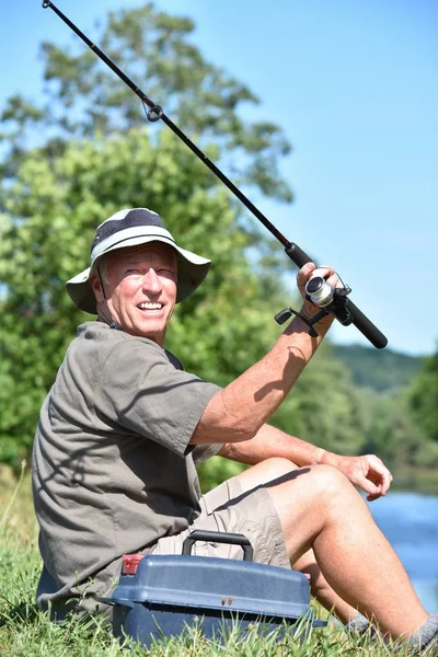 Più vecchio pensionato maschio pescatore e felicità con asta e bobina colata asta — Foto Stock