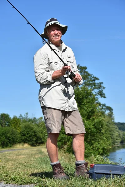 Усміхнений старший чоловічий рибалка з ловчими вушками — стокове фото
