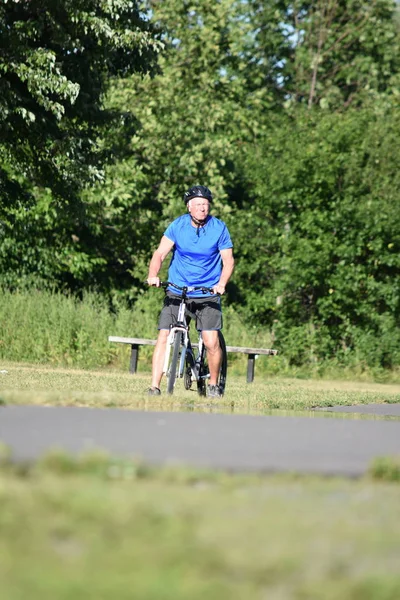 Bicicleta ciclista masculina solitaria con casco a caballo — Foto de Stock