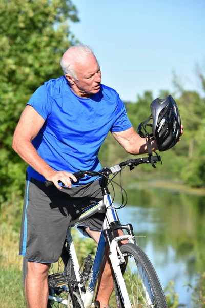 Confundido jubilado atlético hombre con casco de montar en bicicleta — Foto de Stock