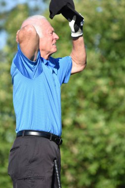 Golf sopası olan endişeli yaşlı atletik adam.