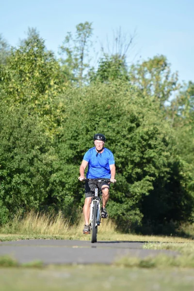 Adulto atleta masculino y ejercicio usando casco a caballo bicicleta — Foto de Stock