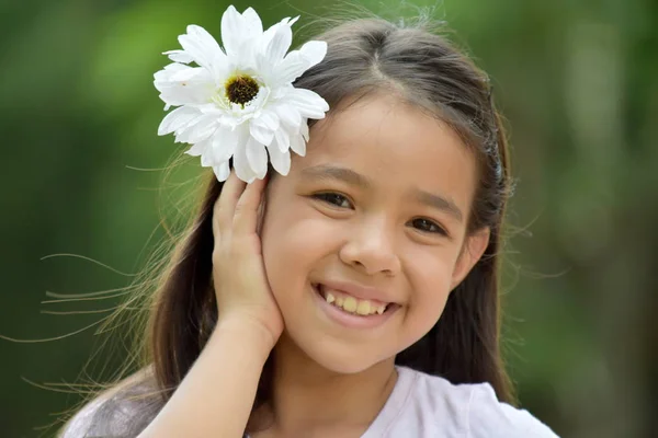 Niedliches Mädchen lächelt mit einem Gänseblümchen — Stockfoto