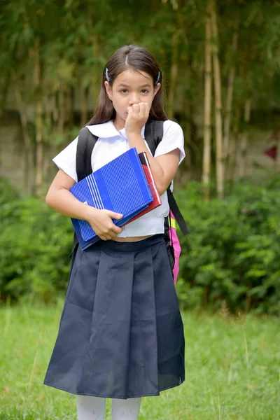 本で制服を着るのを恐れるアジアの女子学生を準備する — ストック写真