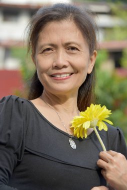 Asyalı Son Sınıf Kadın Bir Daisy ile Gülümsüyor