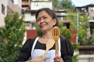 Kıdemli Aşçı ve Mutluluk Önlük takıyor Utensilli