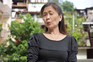 Yaşlı bir Asyalı Yaşlı Kadın Göz Kırpıyor