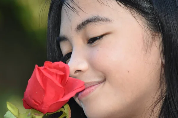 Uma adolescente menina cheirando rosa — Fotografia de Stock