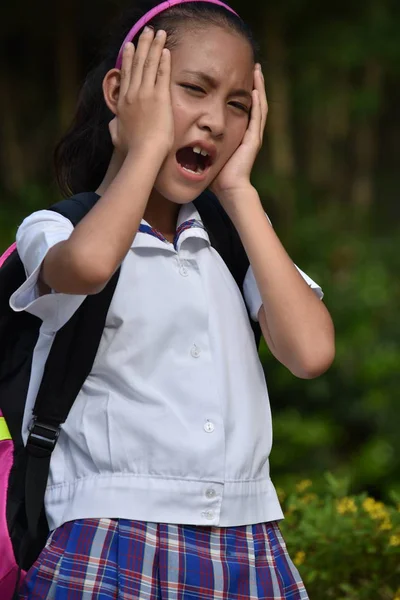 Úzkostlivá rozmanitá školní dívka ve školní uniformě s knihami — Stock fotografie