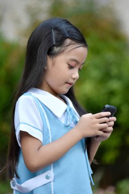 Telefonlu okul üniforması giyen tatlı bir kız öğrenci.