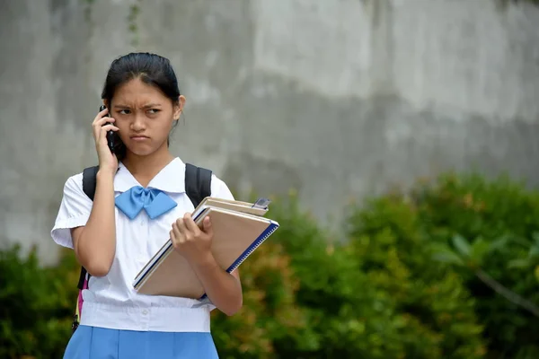 Menšinové školní dívka pomocí mobilního telefonu a nešťastné — Stock fotografie