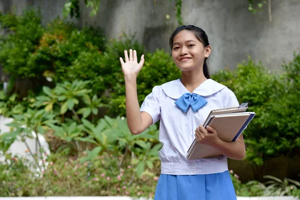 Giovane minorenne studentessa che saluta con libri scolastici — Foto Stock