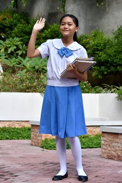年轻的菲律宾女学生带着课本摇摆不定 — 图库照片