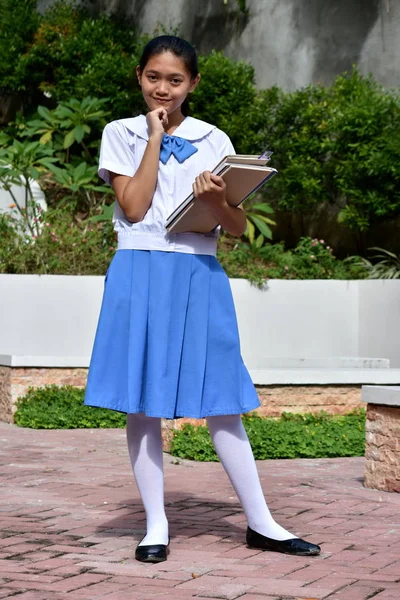 Okul kitaplarıyla düşünen Asyalı tatlı bir kız. — Stok fotoğraf