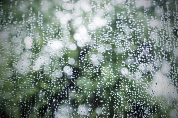 雨滴やボケ雨の季節と窓からすに水滴の抽象的な背景をぼかした写真 — ストック写真