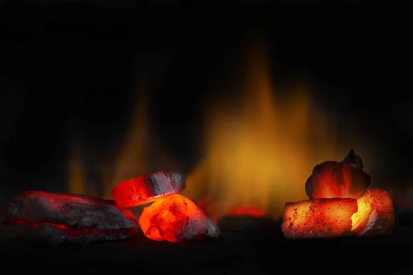 Red hot coal bars in focus op donkere achtergrond met vlammen. Achtergrond van ruwe kool met zachte focus uitsluiting met kleur en temperatuur. — Stockfoto