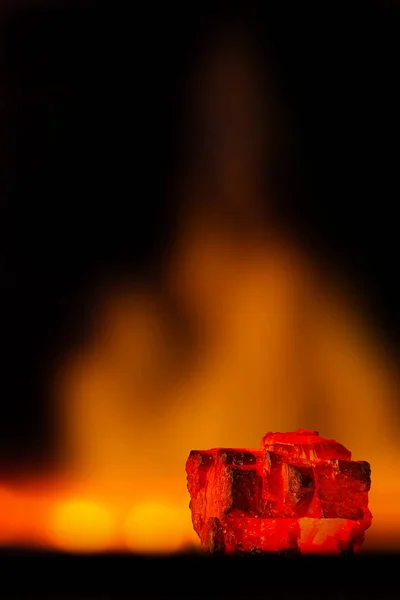Red hot coal bars in focus on dark background with flames. Background of raw coal with soft focus exclusion with color and temperature. — Stock Photo, Image